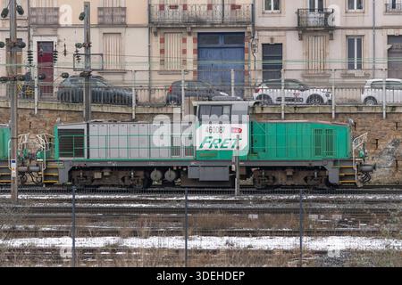 Nancy, Frankreich - Blick auf einen grauen und grünen schweren Jäger BB 60000, der den Bahnhof Nancy überquert, mit Gebäuden und Autos im Hintergrund. Stockfoto