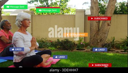 Meditierende Seniorin mit Langarmshirt und Leggings auf rosa Matte im Garten, mit Überzügen Stockfoto