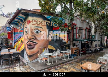 Izmir, Türkei - 1. April 2025: Farbenfrohes Dario Moreno-Wandgemälde an einer Café-Wand mit Sitzgelegenheiten im Freien in der Dario Moreno Street, in der Nähe des historischen Asansor Stockfoto