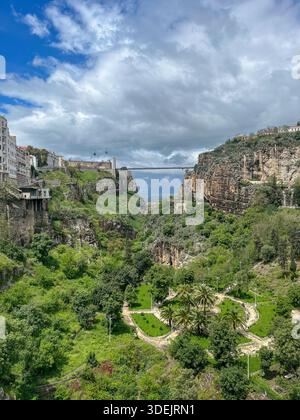 Blick aus einem hohen Winkel auf die ikonische Hängebrücke Sidi M'Cid, die über den tiefen Rhumel River Canyon in Konstantine, Algerien, überspannt. Stockfoto