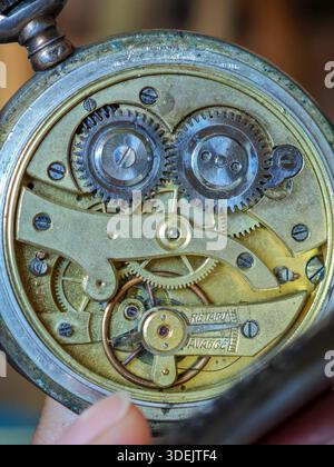 Detaillierte Makroaufnahme der inneren Messingzahnräder und des Mechanismus einer antiken Taschenuhr. Stockfoto