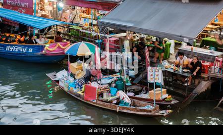Amphawa Floating Market, Thailand 5. Dezember 2025. Farbenfrohe Boote verkaufen lokale Köstlichkeiten, während Besucher die lebhafte Atmosphäre genießen. Der Markt ist voller Menschen, die in die thailändische Kultur und Küche eintauchen. Stockfoto