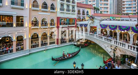 Gondelfahrt entlang des offenen Kanals in der Venice Grand Canal Mall in McKinley Hill (Megaworld Lifestyle Malls), Taguig City, Metro Manila, Philippinen Stockfoto
