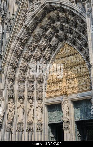 Faszinierende Nahaufnahme des komplizierten gotischen Bogens und der Skulpturen des Kölner Doms. Dieses Bild zeigt die meisterhafte Handwerkskunst Stockfoto