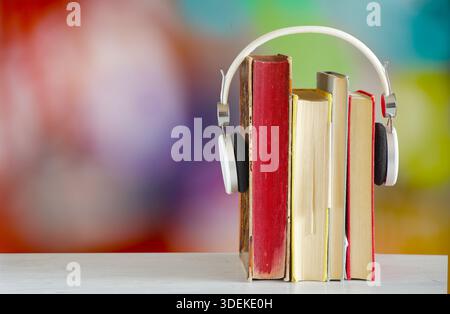 Hörbücher für den Frühling mit Büchern, Kopfhörern und farbenfrohen, verschwommenen Hintergrund Stockfoto