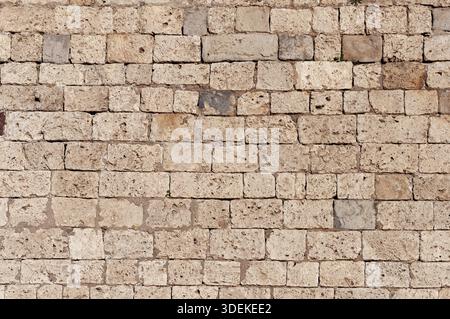 Die Textur der alten braunen Kalksteinwand als Hintergrund Stockfoto
