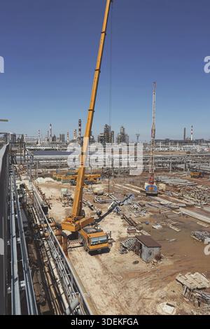 Auf der Baustelle des neuen Werks steht ein großer gelber Lkw-Kran einsatzbereit Stockfoto