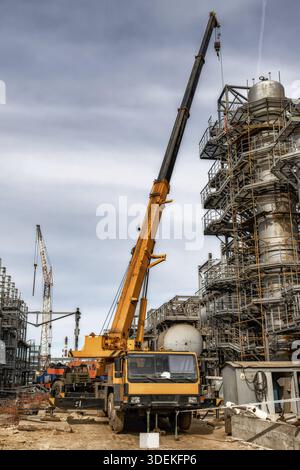 Auf der Baustelle einer Ölraffinerie steht ein großer gelber Autokran Stockfoto