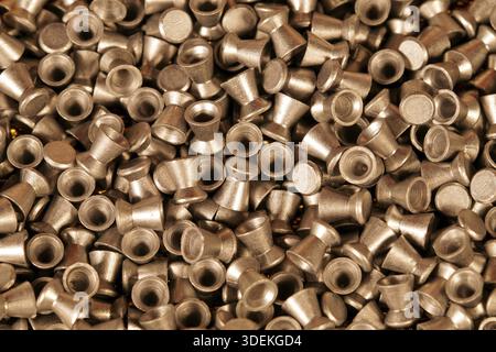 Goldene Blei-Luftgewehrkugeln Nahaufnahme der Hintergrundstruktur, Auswahl an Pellets eines Luftgewehrs. Nahaufnahme. Hintergrund der Pistolenkontrolle. Konzept der Aufnahme, Stockfoto