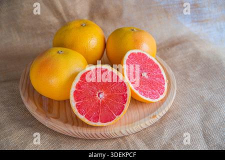 4 Grapefruits, einer von ihnen in zwei Hälften. Immer noch leben. Stockfoto