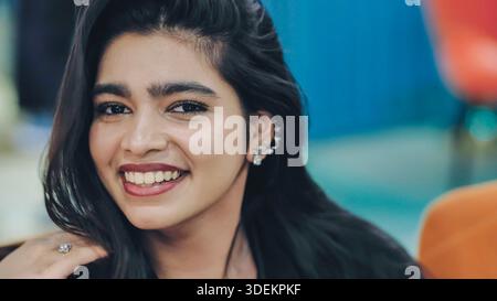 Eine junge Frau lächelt und drückt Glück, Persönlichkeit und Selbstvertrauen aus Stockfoto