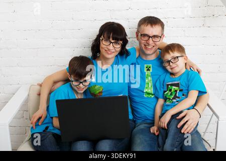 Vierköpfige Familie mit Brille und Laptop. Stockfoto