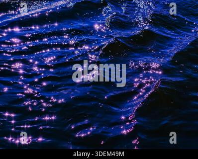 Glitzerndes Morgenlicht auf kräuselndem Blauen Meer – elegante abstrakte Wasserstruktur mit hellen Sonnenreflexionen und Tapetenästhetik Stockfoto