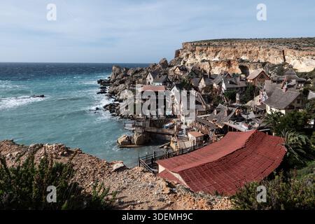 Panoramablick auf Popeye Village, das auf Kalksteinklippen über dem Mittelmeer thront und die ikonischen Holzgebäude des berühmten Films zeigt Stockfoto