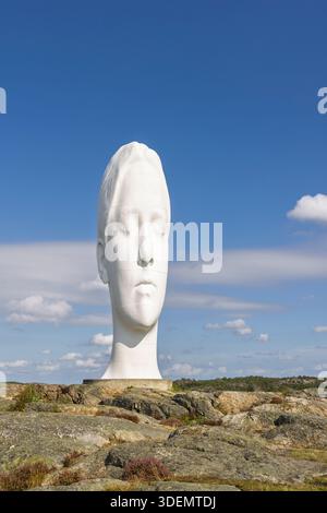 Tjorn, Schweden - 3. September 2025: Ein großer weißer Skulpturenkopf an der Skulptur i Pilane erhebt sich über einem felsigen Hügel, der von Grün umrahmt wird Stockfoto