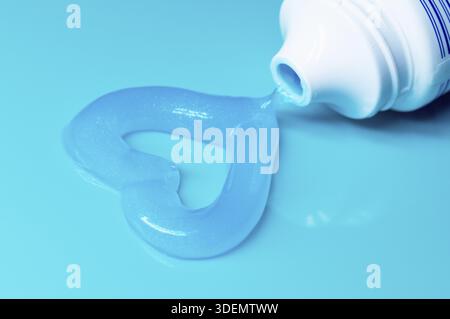 Ein Herz aus blauer Zahnpasta. Gel-Zahnpasta in Herzform auf Blau. Guten Morgen, gute Nacht. Kopierbereich für Text Stockfoto