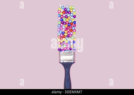 Edelsteine. Edelsteine Herzform Zusammensetzung. Kreatives Layout aus mehrfarbigen Glasjuwelen und Pinsel auf rosa Pastellhintergrund. Minimale flache Lage. Stockfoto