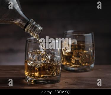 Cognac wird aus einer Flasche in ein Glas gegossen Stockfoto