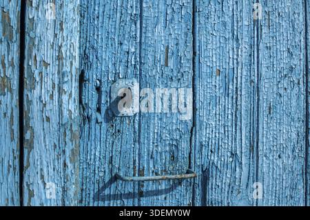 Alte Holzbretter mit zerbröckelter, rissiger blauer Farbe in der Nähe Blauer Hintergrund Stockfoto
