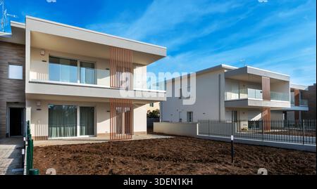 Die neuen Apartments bieten innovative Architektur mit Balkonen und Glasgeländern unter blauem Himmel Stockfoto