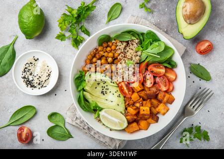Gesunde vegane Mittagsschale mit Zutaten. Avocado, Quinoa, Süßkartoffeln, Tomaten, Spinat und Kichererbsen Gemüsesalat. Draufsicht Stockfoto