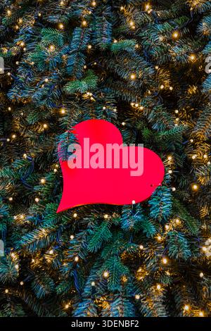 Ein rotes Herz als Weihnachtsdekoration auf einem Baum Stockfoto