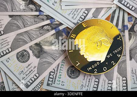 KIEW, UKRAINE - 13. DEZEMBER 2025 Trump Goldmünze auf großen Mengen von US-Dollar-Banknoten Stockfoto