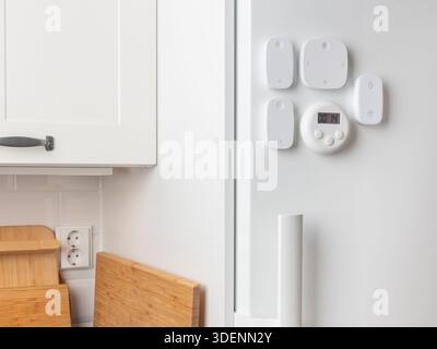 Smart Home Fernbedienungen sind am Kühlschrank montiert, einschließlich Tastenkombinationen und Multifunktionssteuerungen, die minimalistische, flexible Beleuchtungssteuerung bieten Stockfoto
