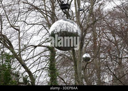 Dublin, Irland - 29. Dezember 2025: Große reflektierende silberne Discokugeln hängen über Bäumen im Marlay Park in South Dublin an einem kalten, trockenen, bewölkten Nachmittag in der irischen Hauptstadt Stockfoto