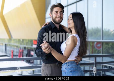 Glückliches Paar, das zusammen in einem modernen Flur tanzt. Stockfoto