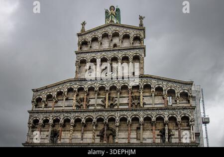 Fachada de la iglesia de San Michele in Foro en Lucca, Italia, ejemplo de arquitectura románica italiana en Mármol blanco bajo un cielo nublado. Stockfoto