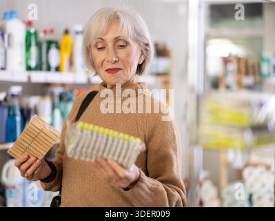 Eine Frau, die sich im Laden eine Wäschespanne ausgesucht hat Stockfoto