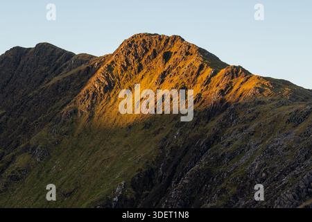 Goldenes Licht auf Mount Snowdon (Yr Wyddfa), das steile Grate und Felsen hervorhebt Stockfoto