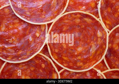 Chorizo-Chorizo-Scheiben für Gourmet-Platte, Ringen mit geräuchertem Fleisch, überlappend mit glänzenden Fettflecken, gestylt für gehobene Unterhaltung und Feinkost Stockfoto