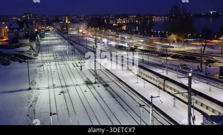 Verschneite Nacht an der Westseite des Bahnhofs Rorschach, vom Stadtlift aus gesehen, mit einem ICN auf Gleis 4 zur Abfahrt bereit. Stockfoto