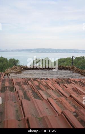 Rustikales, braunes Ziegeldach und Meerblick. Stockfoto
