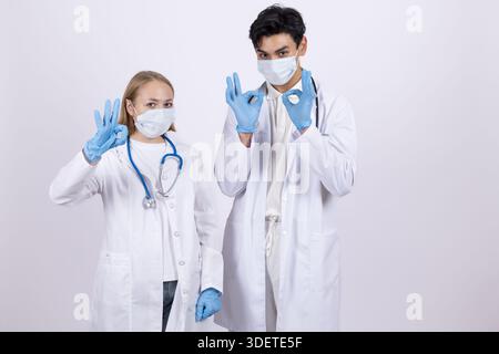 Zwei Ärzte in weißen Mänteln mit medizinischen Masken Stockfoto