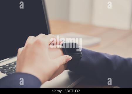 Nahaufnahme einer Frau mit Smart Watch am Arbeitsplatz Stockfoto