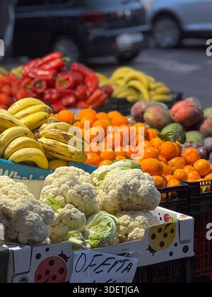Frisches Obst wie Bananen, Orangen und Blumenkohl werden an einem Marktstand unter freiem Himmel in Valencia angeboten. Stockfoto