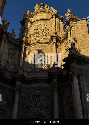 Nahaufnahme der reich verzierten barocken Kirchenfassade in Valencia, die im späten Nachmittagssonnenlicht leuchtet. Stockfoto