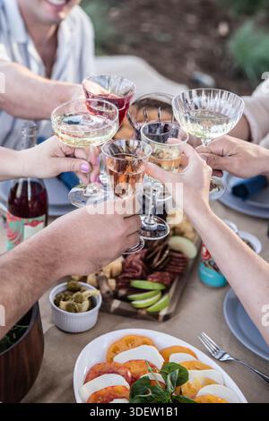 Freunde, die beim Festessen im Freien Gläser hochziehen Stockfoto
