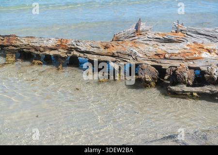 Flaches klares Meerwasser, das über flache Küstenfelsen fließt. Natürliche Texturen, warmes Sonnenlicht und ruhige Atmosphäre schaffen eine ruhige Küstenlandschaft für die Natur Stockfoto