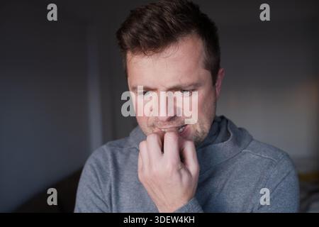 Besorgte männliche Person mit einer schlechten Angewohnheit, Konzept von psychischen Problemen oder Geschäftsscheitern. Stockfoto