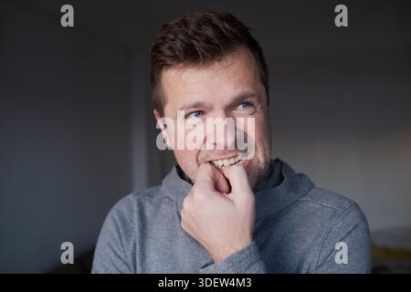 Besorgte männliche Person mit einer schlechten Angewohnheit, Konzept von psychischen Problemen oder Geschäftsscheitern. Stockfoto