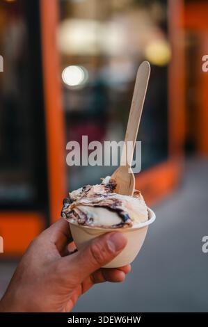 Hand hält eine Tasse Eis im Zentrum von Traverse City, Michigan Stockfoto