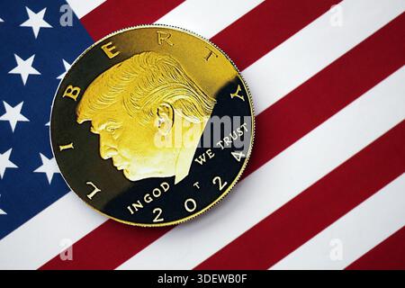 KIEW, UKRAINE - 13. DEZEMBER 2025 Trump Goldmünze auf US-Flagge mit Sternen und Streifen in der Nähe Stockfoto