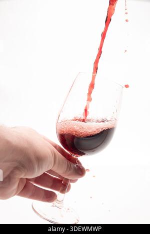 Ein Glas Kristall, gefüllt mit Rotwein vor weißem Hintergrund Stockfoto