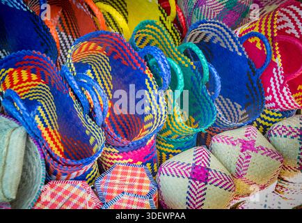 Gewebte Körbe aus Kunststoff und traditionellen Materialien zum Verkauf an einem Verkaufsstand auf dem Hauptmarkt von Anjoma in Fianarantsoa, einem geschäftigen Zentrum des täglichen Lebens und des Handels im Herzen von Madagaskars zentralen Hochland. Der Markt ist bekannt für seine große Auswahl an lokalen Produkten, handwerklichen Waren und eine lebhafte Atmosphäre. Handgewebtes Korbgeschirr ist ein prominentes Merkmal, das sowohl als praktische Haushaltsgegenstände als auch als schöne handwerkliche Ware dient. Die gewebten Produkte spiegeln die starke Handwerkstradition der Region wider, vor allem unter den Betsileo-Einwohnern, und zeigen lokale Kreativität und Fähigkeiten. Stockfoto