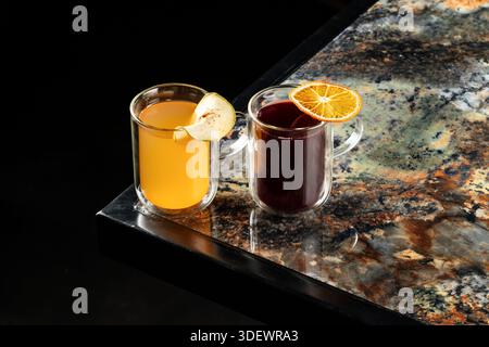 Elegantes Arrangement mit Blick von oben mit einem Glas goldenem Apfelwein und einem reichhaltigen Rotwein, mit lebhaften Farben und raffinierten Glaswaren, perfekt für Stockfoto