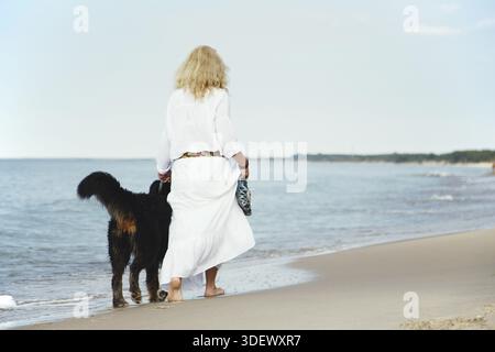 Berner Berghund und Frau spazieren in der Nähe des Meeres Stockfoto